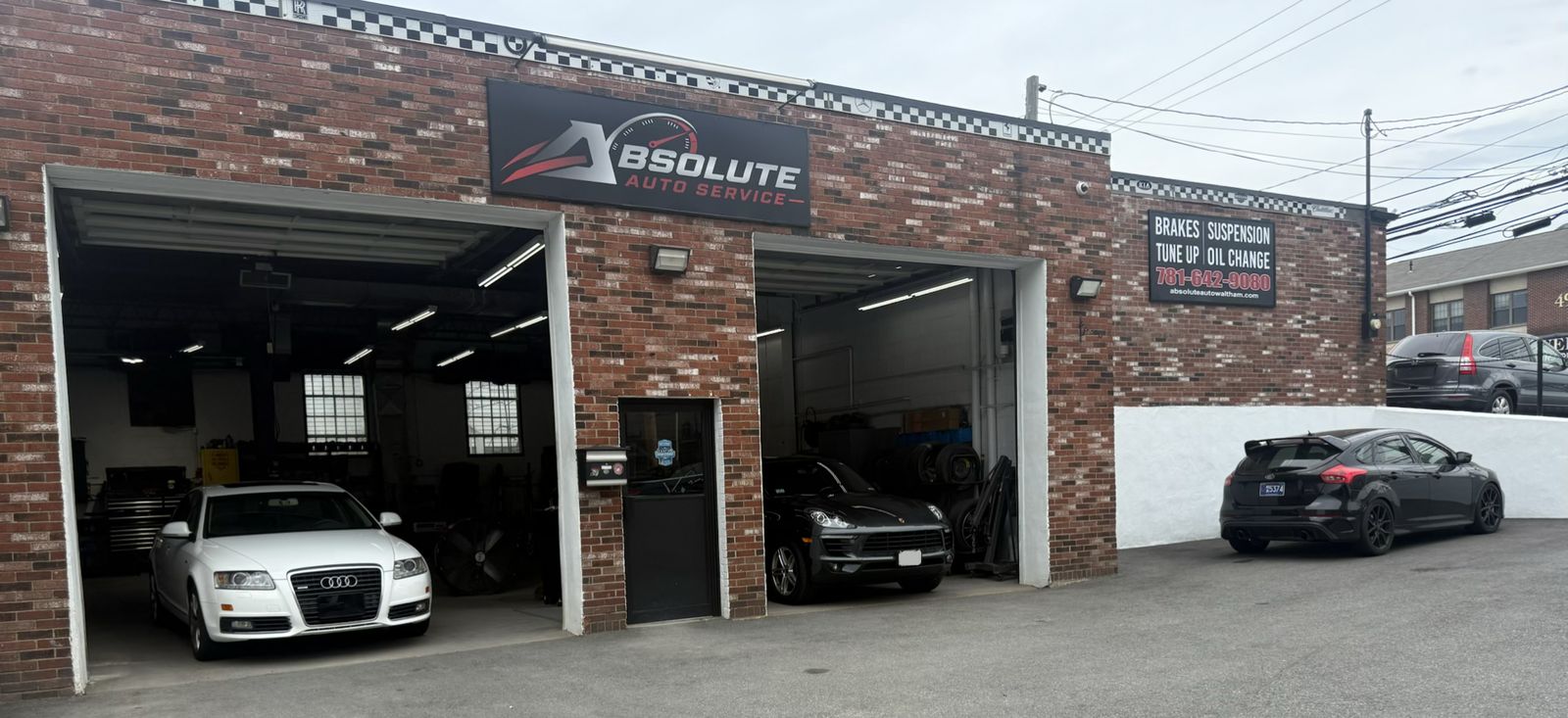 Absolute Auto Service at 50 River Street in Waltham, MA — two service bays open with vehicles inside